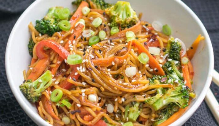A bowl of colorful veggie garlic noodles with mushrooms